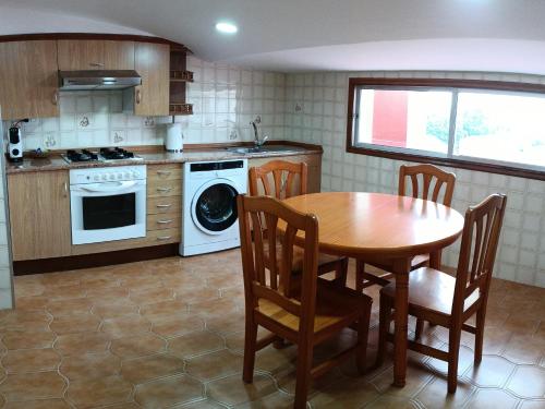 坎巴多斯ATICO B&P CAMBADOS的厨房配有桌子、炉灶和水槽。