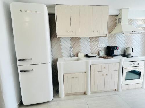 阿斯提帕莱亚镇Gerani Deluxe Houses的厨房配有白色冰箱和水槽