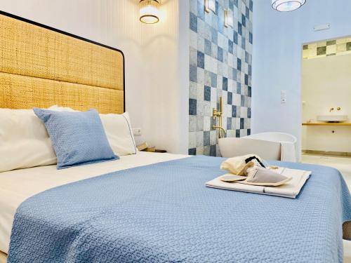 阿斯提帕莱亚镇Gerani Deluxe Houses的一间卧室配有一张蓝色的床,上面有毛巾