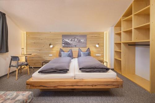 乌姆豪森Apart Bergzeit的一间卧室配有一张大床和木制床头板