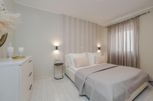 扎达尔Villa Karla的白色的卧室设有白色的床和窗户。