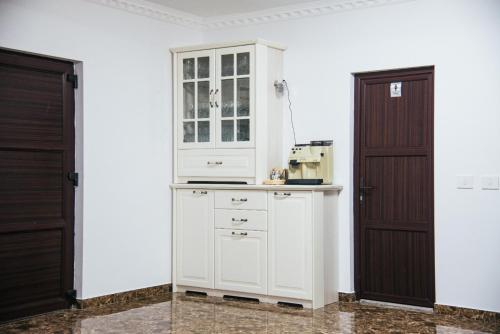 OrlatCasa Munty的一间厨房,配有白色橱柜和两扇门