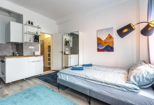 布达佩斯ALLEE BUDA Apartment的一间白色卧室,配有床和厨房