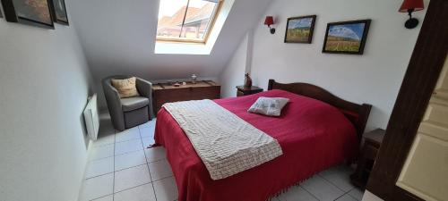 贝格海姆Le Petit Nid的一间卧室配有一张带红色毯子和椅子的床