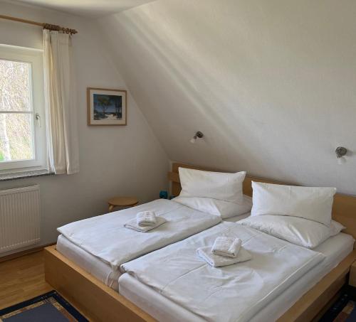奥茨塞巴德·迪尔哈根Ferienhaus Mine Sehnsucht的卧室配有白色的床和2条毛巾
