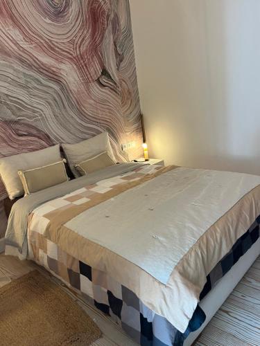 奥比丹Atlas AGUELMAM的卧室配有一张大床,墙上挂有绘画作品