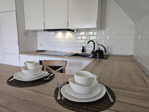 格但斯克Apartament w sercu Oliwy的厨房配有两个盘子和杯子
