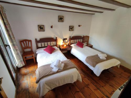 埃里斯特Casa de la Marmota的一间设有两张床和一张桌子及椅子的房间
