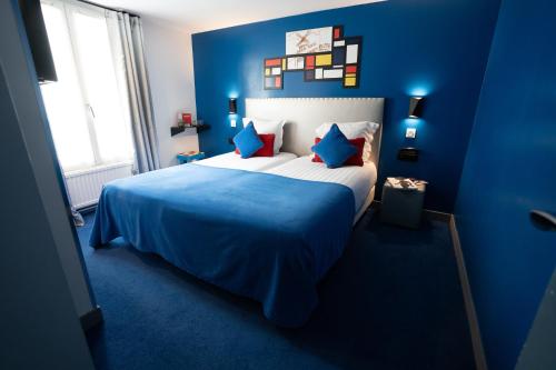 巴黎杜蒙特多尔巴蒂尼奥勒酒店的蓝色卧室配有一张带蓝色床单的大床