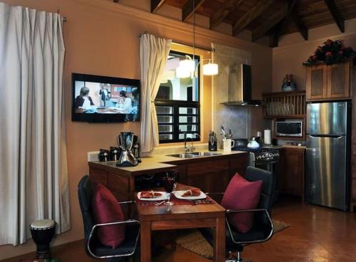 圣伊格纳西奥Villa Cayo的厨房配有桌椅和电视。
