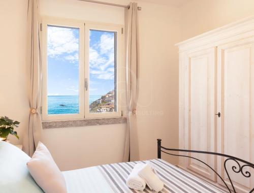 卡斯特尔萨多IL Castello incantato的一间卧室设有一张床和一个海景窗户