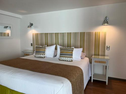 安加罗阿Hotel Boutique La Perouse的一间卧室配有一张大床和枕头