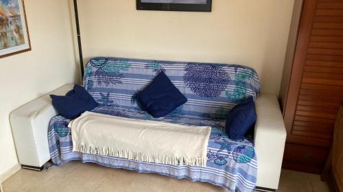 莱斯卡拉APARTAMENTO L'ESCALA的蓝色和白色的沙发,上面有蓝色的枕头