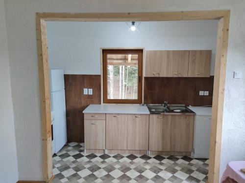 扎布利亚克Vukov Konak - Wolf's lodge的空的厨房,配有木制橱柜和窗户
