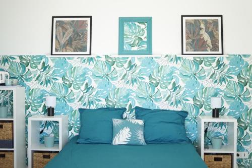 SpéracèdesLes Volets Bleus的一间卧室配有蓝色的床和花卉壁纸