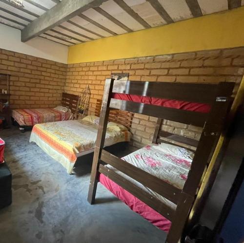 帕尔梅拉斯Sítio Estrela da Manhã的一间卧室设有两张双层床和砖墙