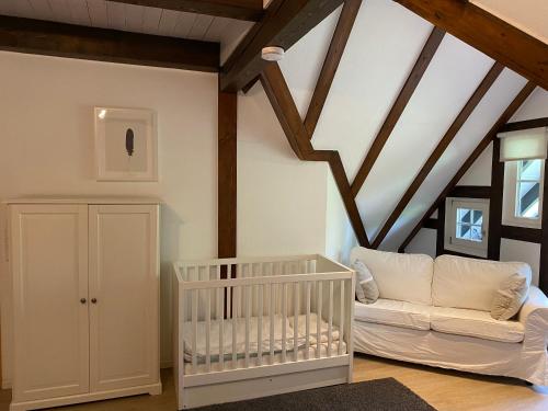 温特贝格Berghof Schmitte的配有木制天花板的客房内的白色婴儿床