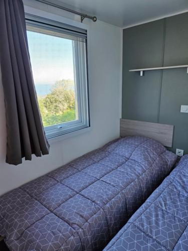 卢米奥Mobilhomme LECCI 3 CHAMBRES AVEC VUE MER EXCEPTIONNELLE的一间卧室设有一张床和一个窗口