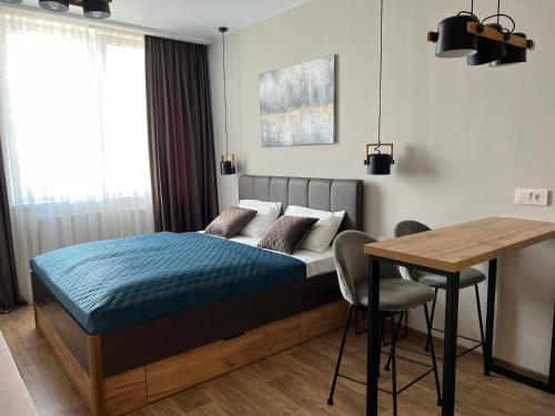 卡缅涅茨-波多利斯基Apartment Two-room "Family Estate"的一间卧室配有一张床和一张木桌