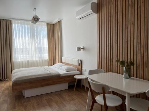 卡缅涅茨-波多利斯基Apartment Two-room "Family Estate"的卧室配有1张床、1张桌子和1张桌子以及椅子。