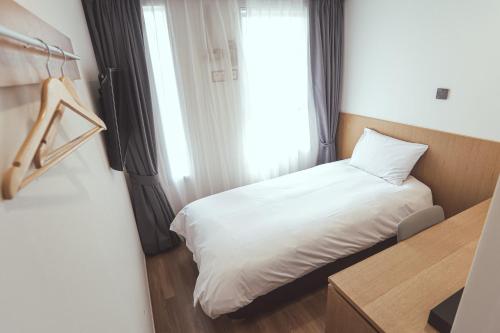西归浦市Kenny Stay Jeju Mosulpo的一间小卧室,配有白色的床和窗户