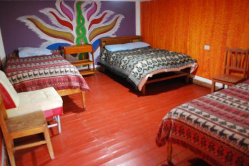 奥兰太坦波Hospedaje La Ñusta的一间卧室设有两张床和彩色的墙壁