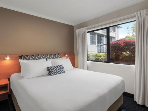 罗托鲁瓦JetPark Hotel Rotorua的一间卧室设有一张大床和一个大窗户