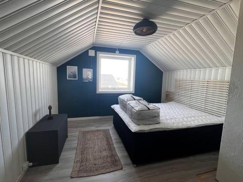 贝勒沃格Storgata 5的一间设有床铺的卧室,位于一间拥有蓝色墙壁的房间