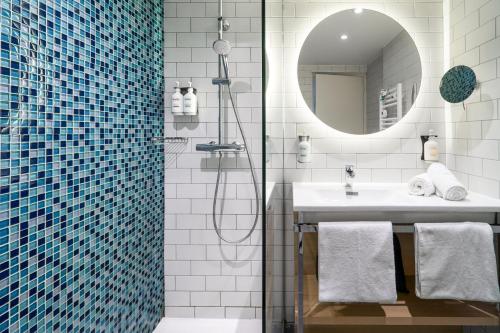 佩皮尼昂Holiday Inn Perpignan, an IHG Hotel的带淋浴、盥洗盆和镜子的浴室