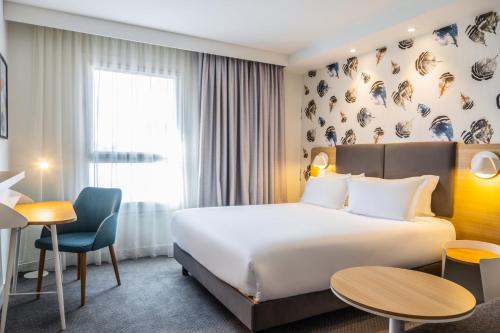 佩皮尼昂Holiday Inn Perpignan, an IHG Hotel的配有一张床和一张书桌的酒店客房