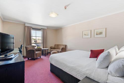 朗塞斯顿朗塞斯顿大总管酒店的配有一张床和一台平面电视的酒店客房