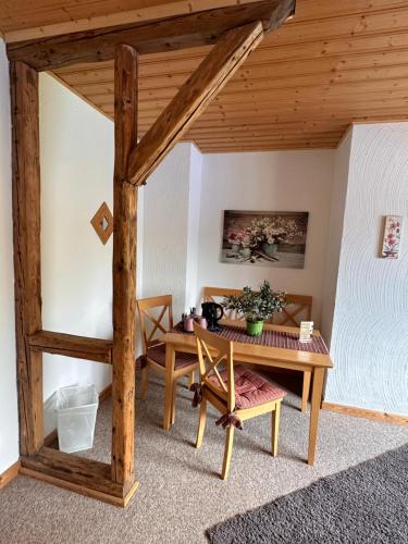 LindLandhaus Tannenhof的客房设有桌子和木制天花板。