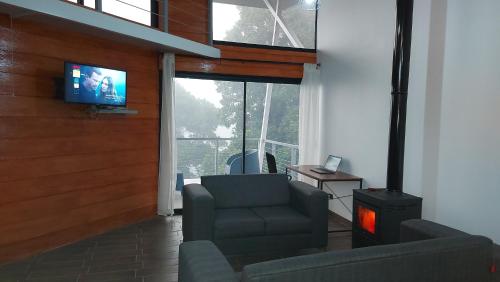 迦太基Casa de montaña Arisa的客厅配有电视、椅子和炉灶。