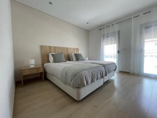 法蒂玛Fátima Apartment - 1min Santuário的白色的卧室设有一张大床和一个窗户