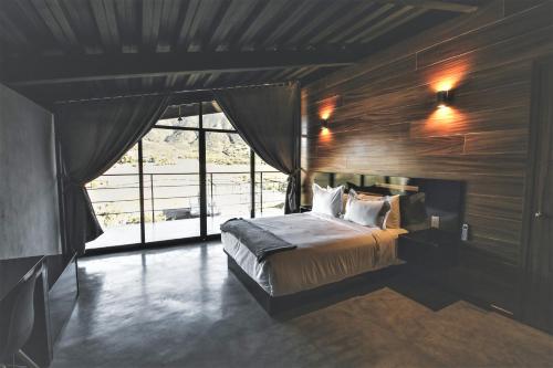瓜达鲁佩镇Origen75 Loft - Villas - Skypool - Viñedo, Valle de Guadalupe的一间卧室设有一张床和一个大窗户