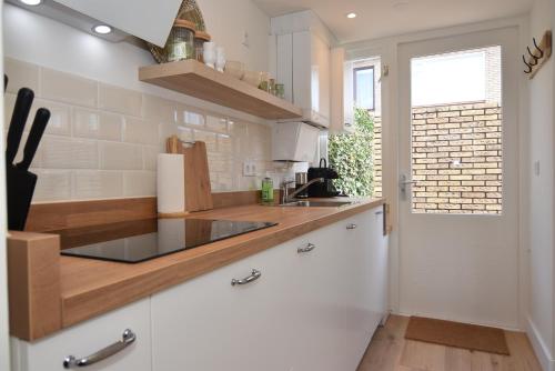 海边的艾格蒙特Casa Feliz的厨房配有白色橱柜和水槽