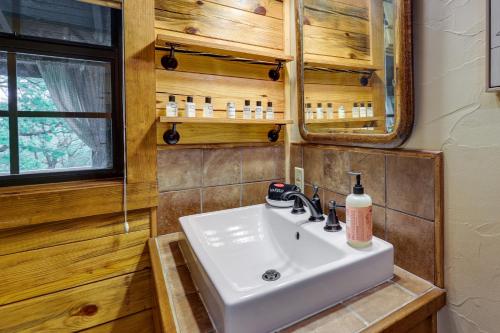 尤里卡斯普林斯Beaver Lake Vacation Rental with Private Hot Tub!的一间带水槽和镜子的浴室