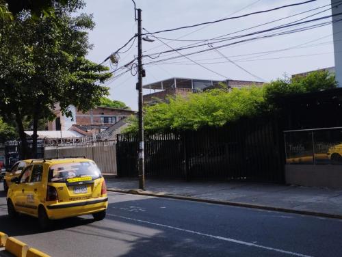 卡利El Hogar de Ami的一辆黄色的汽车在街上行驶