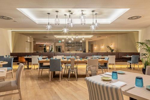 卡帕里卡海岸阿尔德亚杜斯卡普克斯高尔夫＆SPA公寓式酒店的一间带桌椅的餐厅和一间酒吧