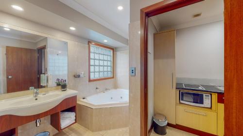 汉密尔顿昆特洛奇汽车旅馆的浴室配有盥洗盆和浴缸。