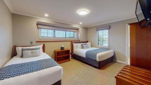汉密尔顿昆特洛奇汽车旅馆的酒店客房设有两张床和窗户。