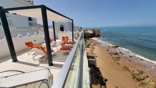 艾西拉Chambre bord de mer的一个带桌椅的海景阳台