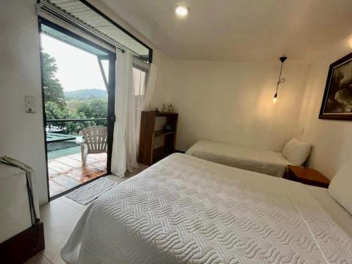 蒙泰韦尔德哥斯达黎加Freddy`s Place B&B的一间带两张床的卧室和一个阳台。