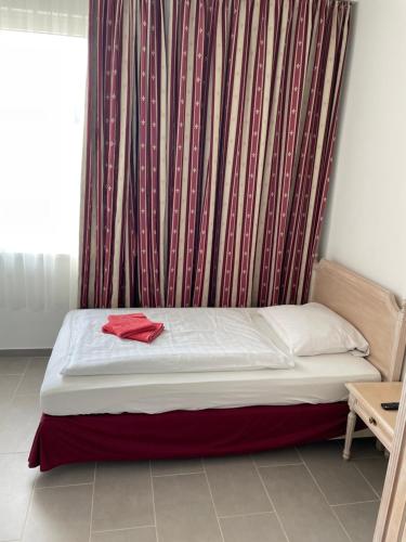 沃尔夫斯堡Pension-Wob 2的红色衬衫上的一个房间里的一个床位
