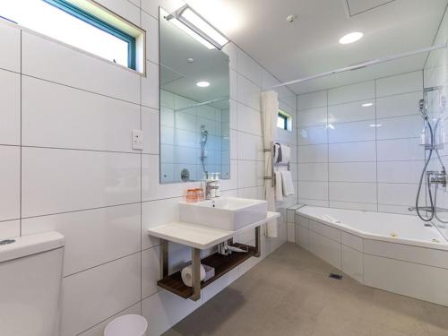 汉密尔顿JetPark Hamilton Airport New Zealand的白色的浴室设有水槽和浴缸。