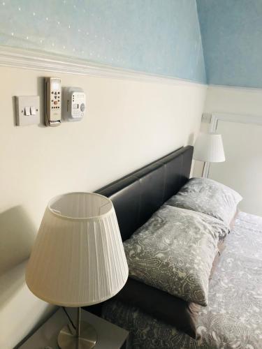 罗奇福德AC Hideout的一间卧室配有一张带两盏灯的床。