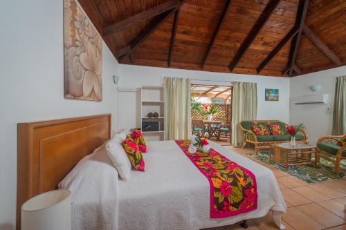 拉罗汤加The Cooks Oasis的一间卧室设有一张床和一间客厅。