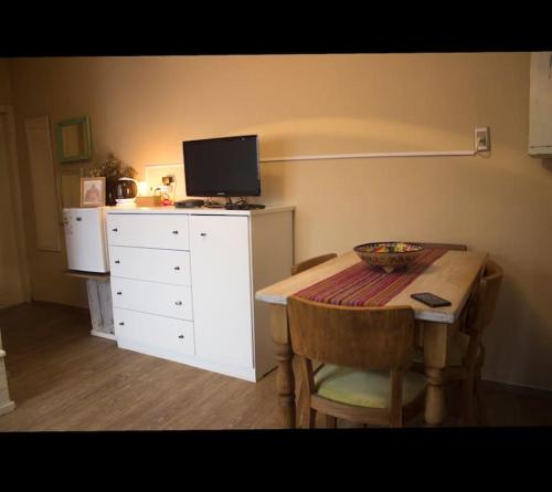 蒙得维的亚Apartamento independiente en alquiler En casa de familia的一间设有桌子和带电视的白色梳妆台的房间