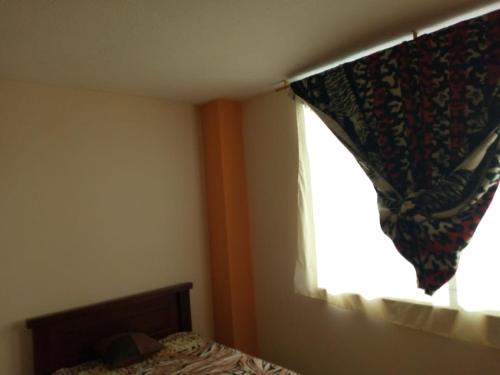 里奥班巴Sun Habitacion Privada的一间卧室配有床和带窗帘的窗户