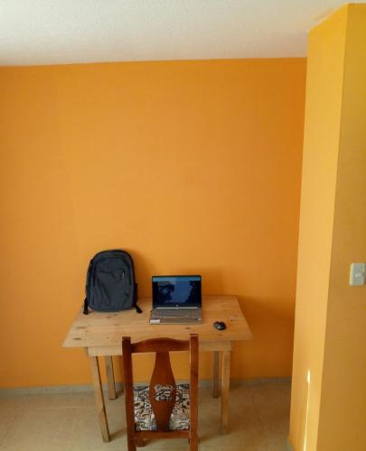 里奥班巴Sun Habitacion Privada的一张桌子,上面有笔记本电脑和背包